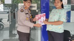 Kasi Humas Polres Poso (kiri) saat membagikan informasi call center polri 110